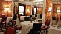 a dining room with white tables and chairs and red walls at Hotel Albani Firenze in Florence