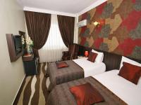 Habitación de hotel con 2 camas y TV en Maya Hotel, en Estambul