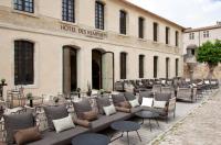 a building with chairs and tables in front of a building at Boutique Hôtel des Remparts & Spa in Aigues-Mortes