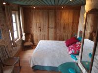 a bedroom with a bed in a room with wooden walls at Riverside Home Cottage in Trèbes
