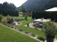 a garden with a table and chairs and an umbrella at Wohlfühlpension Kreischberg in Sankt Georgen ob Murau