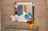 a mirror and a vase with flowers on a table at La Grande Maison De Nans in Nans-les-Pins