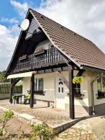 a small house with a balcony and a table at Pension am Silberberg in Gartz an der Oder