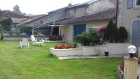 a house with a yard with chairs and flowers at Gîte de la Grande Fontaine in Isches