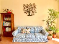 a blue couch in a living room with plants at SpoonDrift Hostal Kenting in Nanwan
