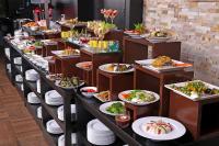 a buffet line with plates and dishes of food at Park Regis Lotus Hotel in Manama