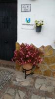 a pot with pink flowers sitting next to a building at Las 4 Lunas in Zahara de la Sierra