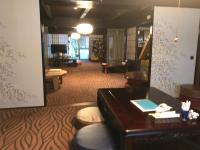 a hotel lobby with a desk and chairs and a room at Terakoya Hanatei in Asago