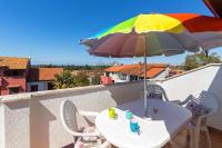 - une table avec un parasol coloré sur un balcon dans l&#39;établissement Elena, à Poreč