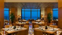 Un restaurante con mesas y sillas y grandes ventanales. en Kempinski Hotel Xiamen, en Xiamen