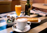 - une tasse de café sur une table avec un verre de jus d'orange dans l'établissement Hostal La Posada, à Torrellano