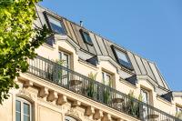a building with a balcony on top of it at Hotel Marais Grands Boulevards in Paris