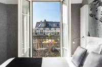 a bedroom with a bed and a view of a city at Hotel Marais Grands Boulevards in Paris