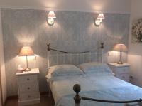 a bedroom with a bed with two night stands and two lamps at Les Jonquilles in Domme