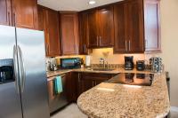 eine Küche mit Holzschränken und einem Edelstahlkühlschrank in der Unterkunft Grand Beach Resort Penthouse 1 in Gulf Shores