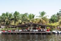 阿西尼Hotel Coucoue Lodge的水面上码头上的餐厅