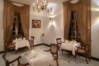 a dining room with white tables and chairs and a chandelier at Manor House Bandarawela By Seven Angels in Bandarawela