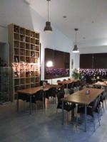 Un restaurante con mesas y sillas de madera y luces. en Centro de Naturaleza Cañada Verde "El Bosque Encantado de Córdoba", en Hornachuelos