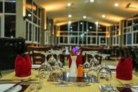 a table with wine glasses and red napkins on it at Oak Ray Elephant Lake in Sigiriya