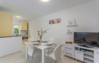 a living room with a white table and a tv at Silver Holiday House in Poreč