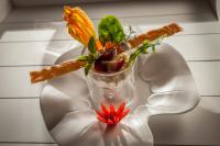 Eine Vase gefüllt mit Speisen auf einem weißen Teller in der Unterkunft Le Jardin aux Sources in Brissac