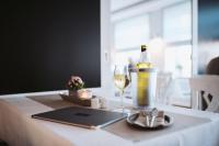a table with a bottle of wine and a glass at Hotel Waastwinj in Utersum