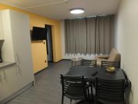 - une chambre avec une table, des chaises et un canapé dans l&#39;établissement Résidence Thermale du Parc, à Ornolac-Ussat-les-Bains
