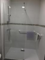 La salle de bains est pourvue d&#39;une douche avec une porte en verre. dans l&#39;établissement Résidence Thermale du Parc, à Ornolac-Ussat-les-Bains
