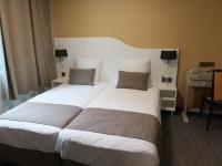 - un grand lit blanc dans une chambre d&#39;hôtel dans l&#39;établissement Résidence Thermale du Parc, à Ornolac-Ussat-les-Bains