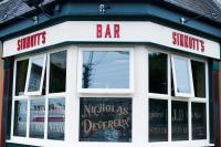 una tienda frente a un bar con ventanas en Sinnotts Bar, en Wexford