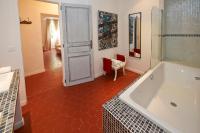 a bathroom with a tub and a red tile floor at La Grande Maison De Nans in Nans-les-Pins
