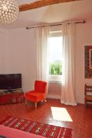 a living room with a red chair and a window at La Grande Maison De Nans in Nans-les-Pins