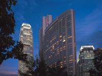 three tall buildings in a city at night at Four Seasons Hotel Hong Kong in Hong Kong