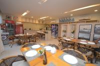 un restaurant avec des tables et des chaises en bois dans l'établissement Beach Living Apartment, à Aquiraz