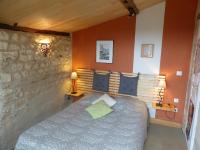 a bedroom with a bed and a stone wall at La Maison Rouge in Chauvigny