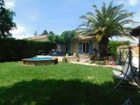 a yard with a house with a palm tree at Les Rosiers in Lapalud