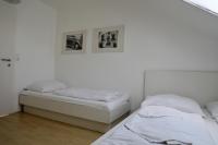 two beds in a room with white walls at Storchencamp Gästehaus Purbach in Purbach am Neusiedlersee