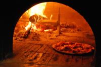 una pizza sta cuocendo in un forno di mattoni di Hotel La Palomba a Mondavio