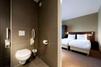 a bathroom with a bed and a toilet in a room at Hotel Espresso in Amsterdam