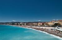 a view of a beach with umbrellas and the ocean at Tiercé Hotel in Cagnes-sur-Mer