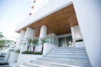 a white house with stairs and palm trees at Boca Beach Residence hotel in Boca Chica