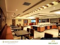 a restaurant with tables and chairs and a bar at MM Legacy - A Bergamont Hotel, Kanchipuram in Kanchipuram