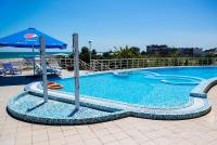 a large swimming pool with an umbrella and chairs at Gold Bugaz Black Sea Hotel Group in Gribovka