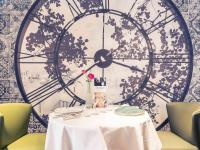una mesa con un reloj en la pared en Mercure Bourg En Bresse, en Bourg-en-Bresse