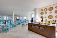 a restaurant with blue chairs and tables and a counter at Aparthotel Tropic Garden in Santa Eularia des Riu