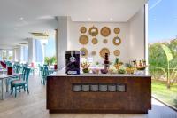 a restaurant with a counter with chairs and tables at Aparthotel Tropic Garden in Santa Eularia des Riu