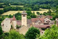 an old castle with a tower in a village at Les chambres de Blanot in Blanot