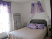 a bedroom with a bed with purple pillows on it at L&#39;Oustau de Bigatié in Lambesc