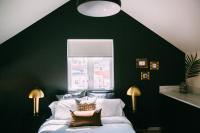 a bedroom with green walls and a bed with pillows at Noon on Sunset Hill in Los Angeles