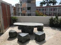 a stone table and stools on top of a balcony at Kuo Kuang Hostel in Hualien City